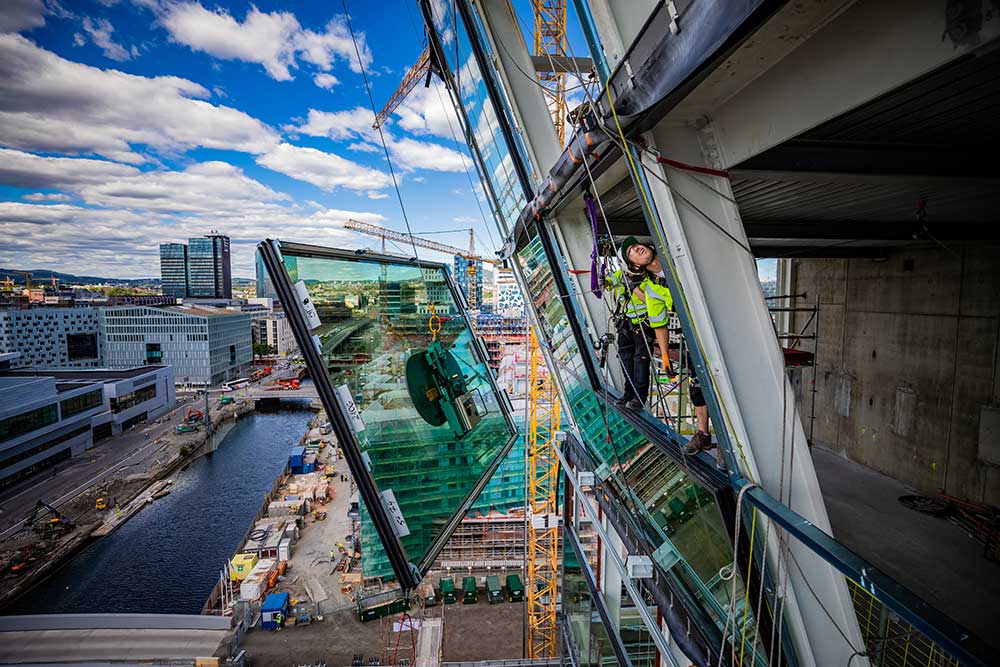 Foto av Klatrer Øysten Halbrend som monterer glass til det nye Munchmuseet.