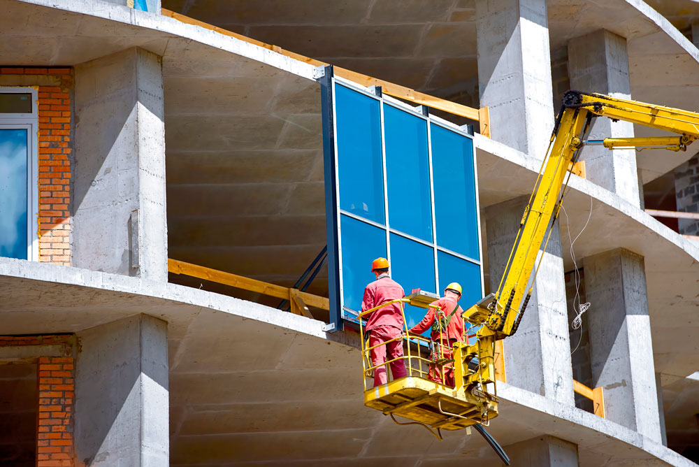 Foto av av glassmontører som installerer glassfasade